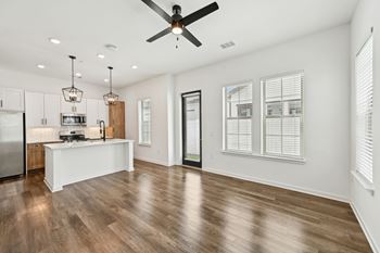A modern kitchen with a wooden floor and white walls.
